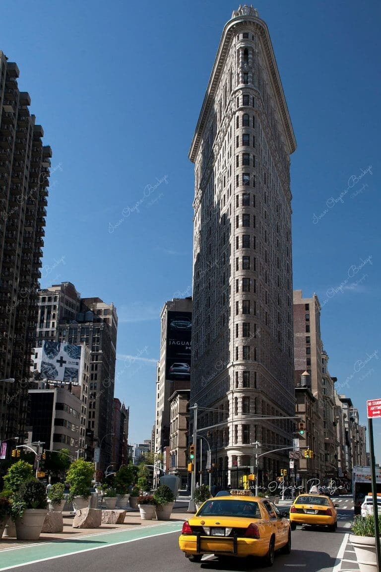 Yellow cabs driving up towards the Flatiron Building in New York, USA