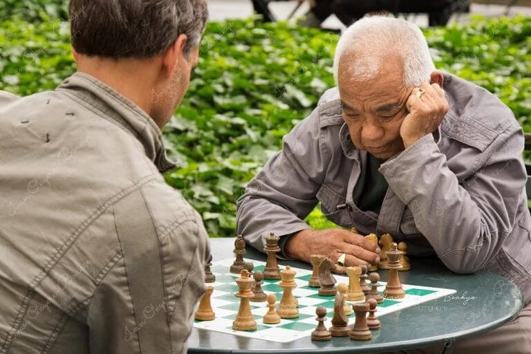 Two men sitting and playing chess in Bryant Park, New York, USA