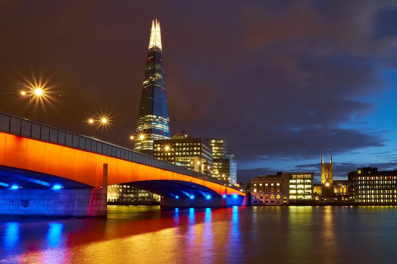 An illuminated London Bridge and The Shard at night, London, United Kingdom