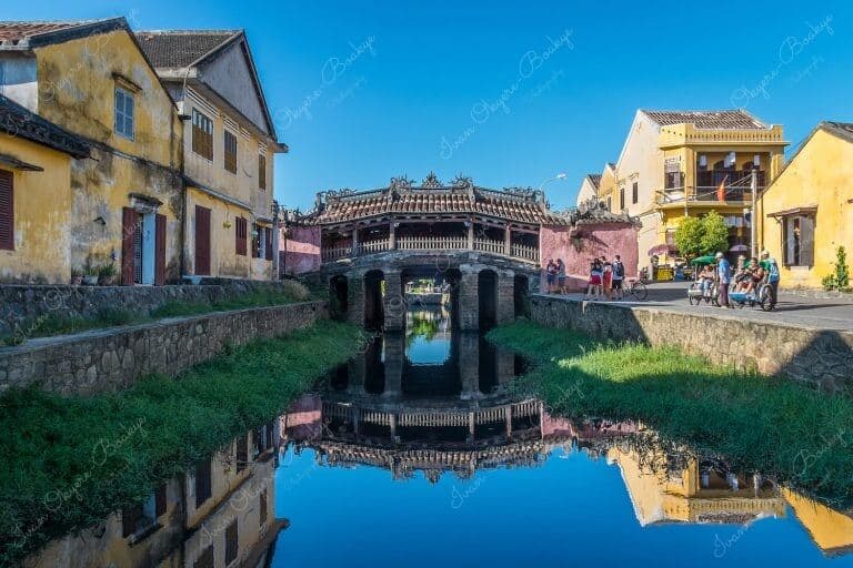 The amazingly colourful and beautiful Japanese Covered Bridge (Cau Nhat Ban) with reflection in the Thu Bon River in Hoi An Old Town, Vietnam