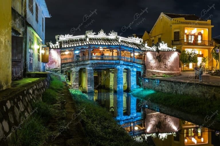 The amazingly colourful and beautiful Japanese Covered Bridge (Cau Nhat Ban) at night with reflection in the Thu Bon River in Hoi An Old Town, Vietnam