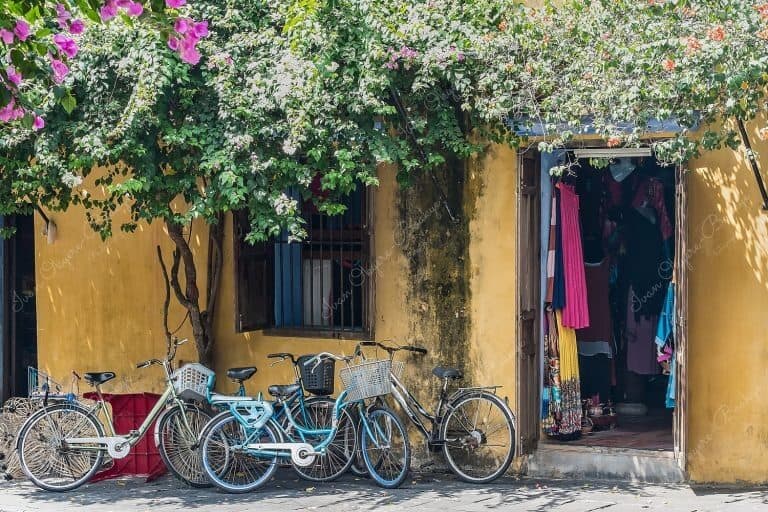 Bicycles parked outside the yellow pastel coloured walls of a women’s clothes store in Tran Phu in Hoi Ann Old Town, Vietnam