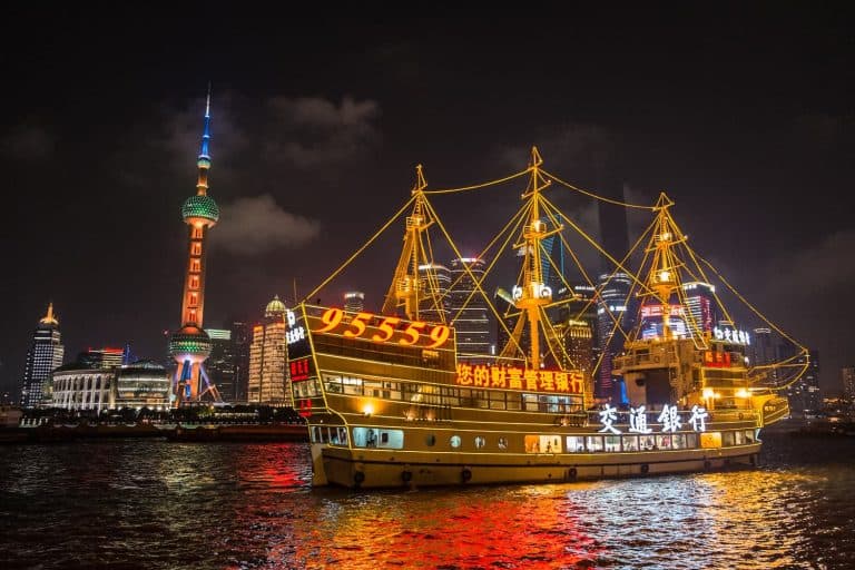 Illuminated Huangpu River cruise boat at The Bund, Shanghai, China