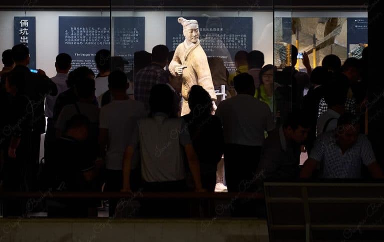 People viewing a Terracotta Army soldier, Xi’an, China