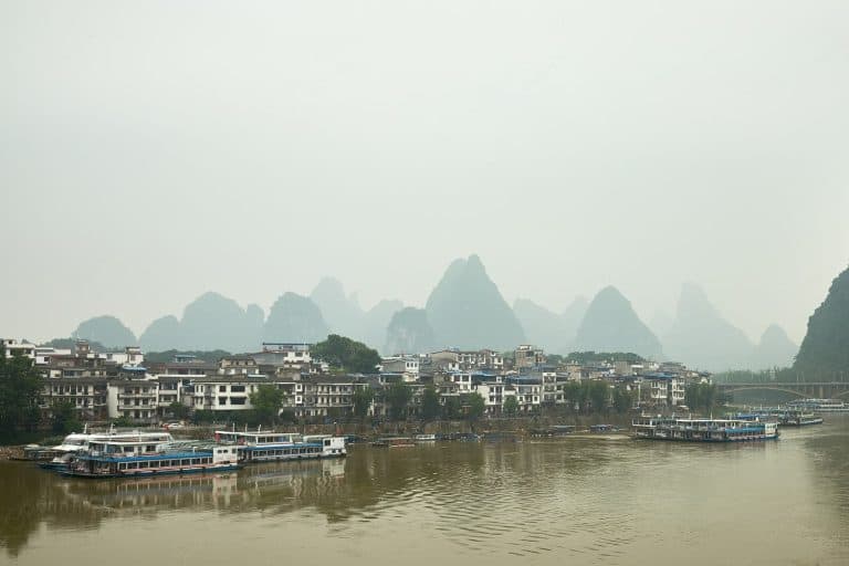Houses on the waterfront with karst mountains in background, Guilin, China