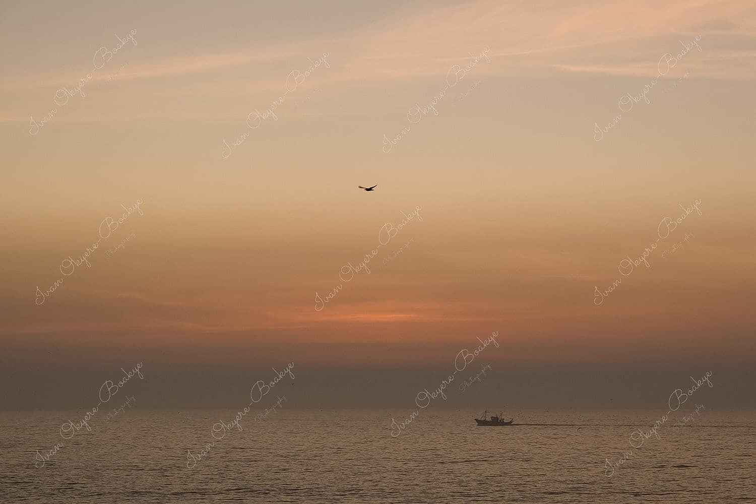 Beautiful pastel coloured seascape at sunset with a lone fishing boat in the sea, Essaouira, Morocco