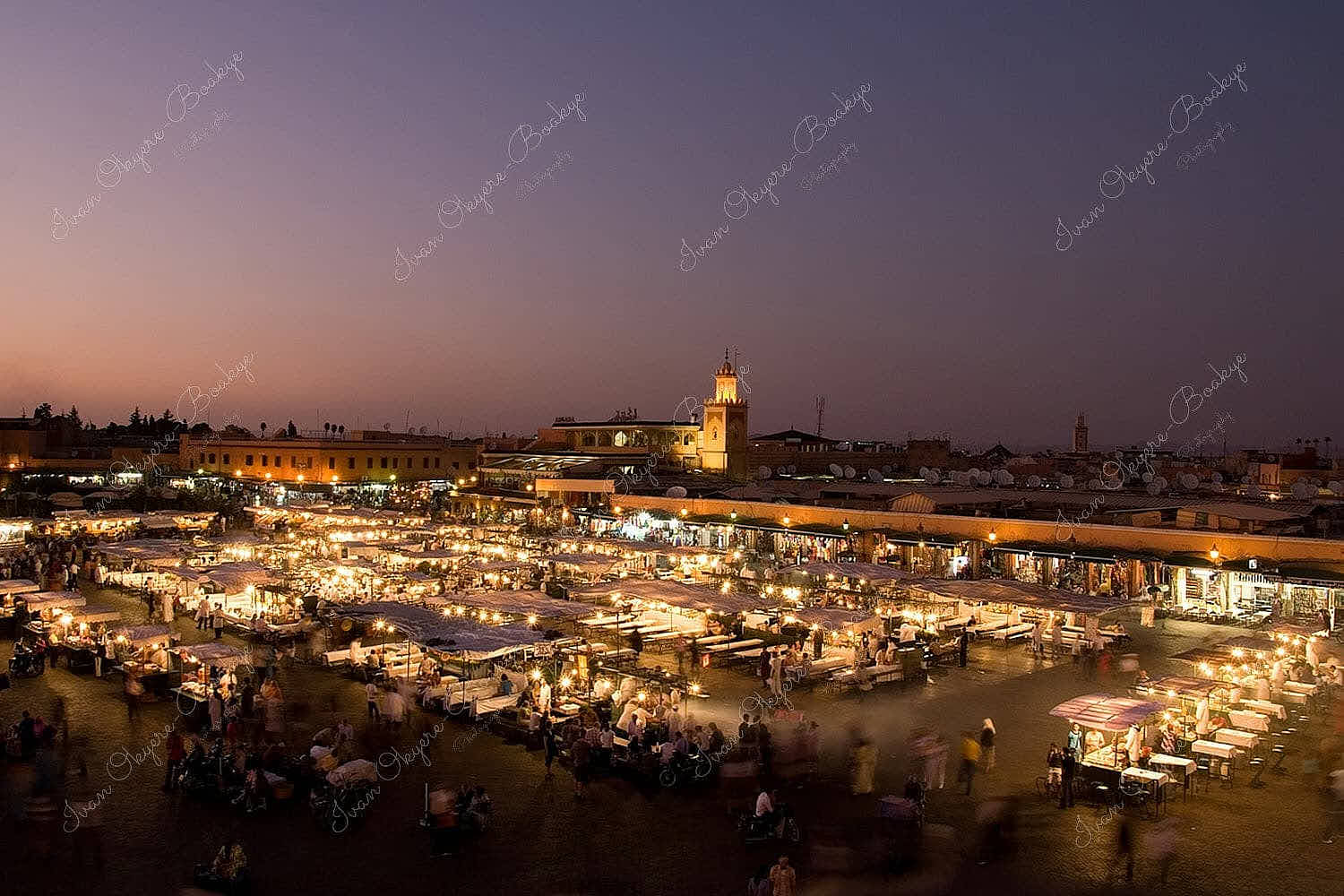Panoramic night view of the famous Djemaa el-Fna night market with smoke rising from the various food stalls, Marrakesh, Morocco