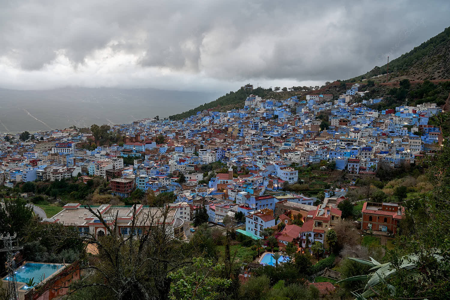 High angle panoramic twilight view of the blue walled old town from Spanish Mosque hill viewpoint, Chefchaouen, Morocco