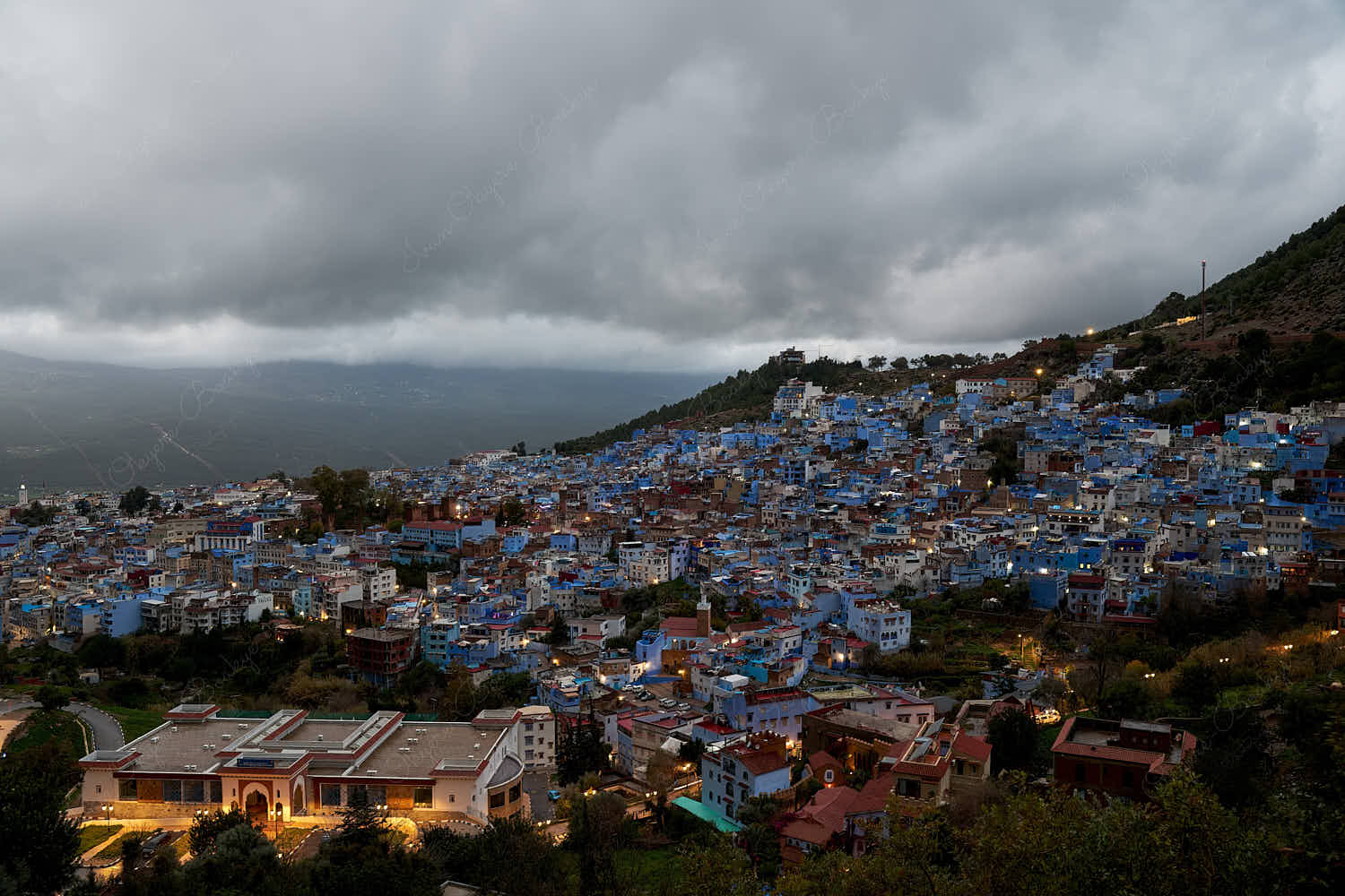 High angle panoramic twilight view of the blue walled old town from Spanish Mosque hill viewpoint, Chefchaouen, Morocco