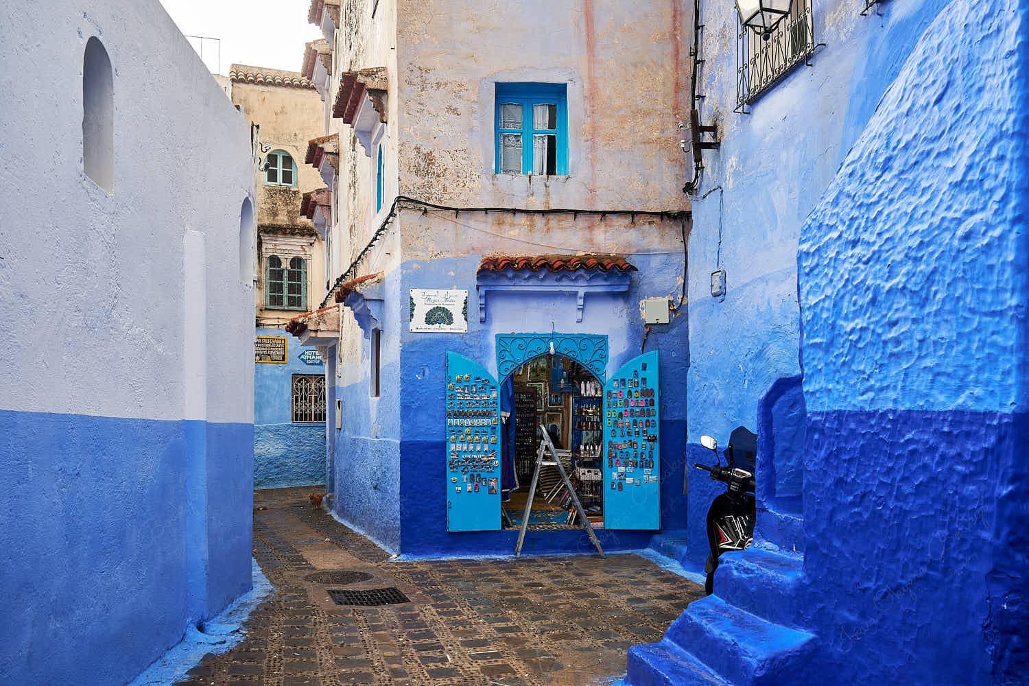 Fridge magnets and other souvenirs shop in an empty street in the blue walled old town medina, Chefchaouen, Morocco
