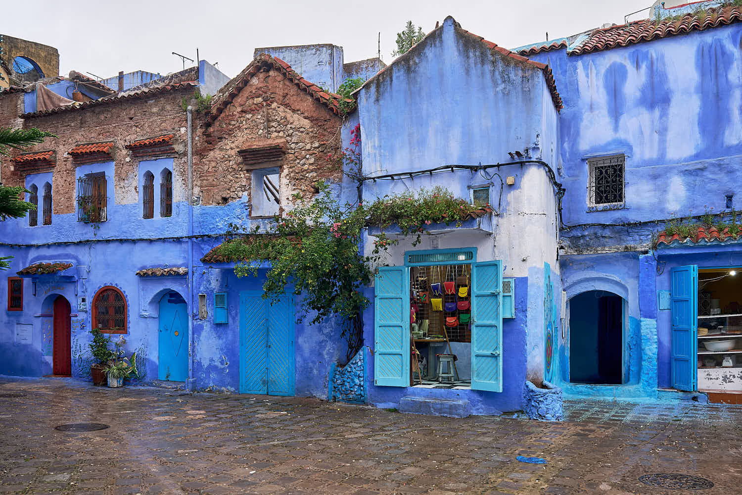 A leather handbags souvenirs shop in empty Place el Haouta in the blue walled old town medina, Chefchaouen, Morocco