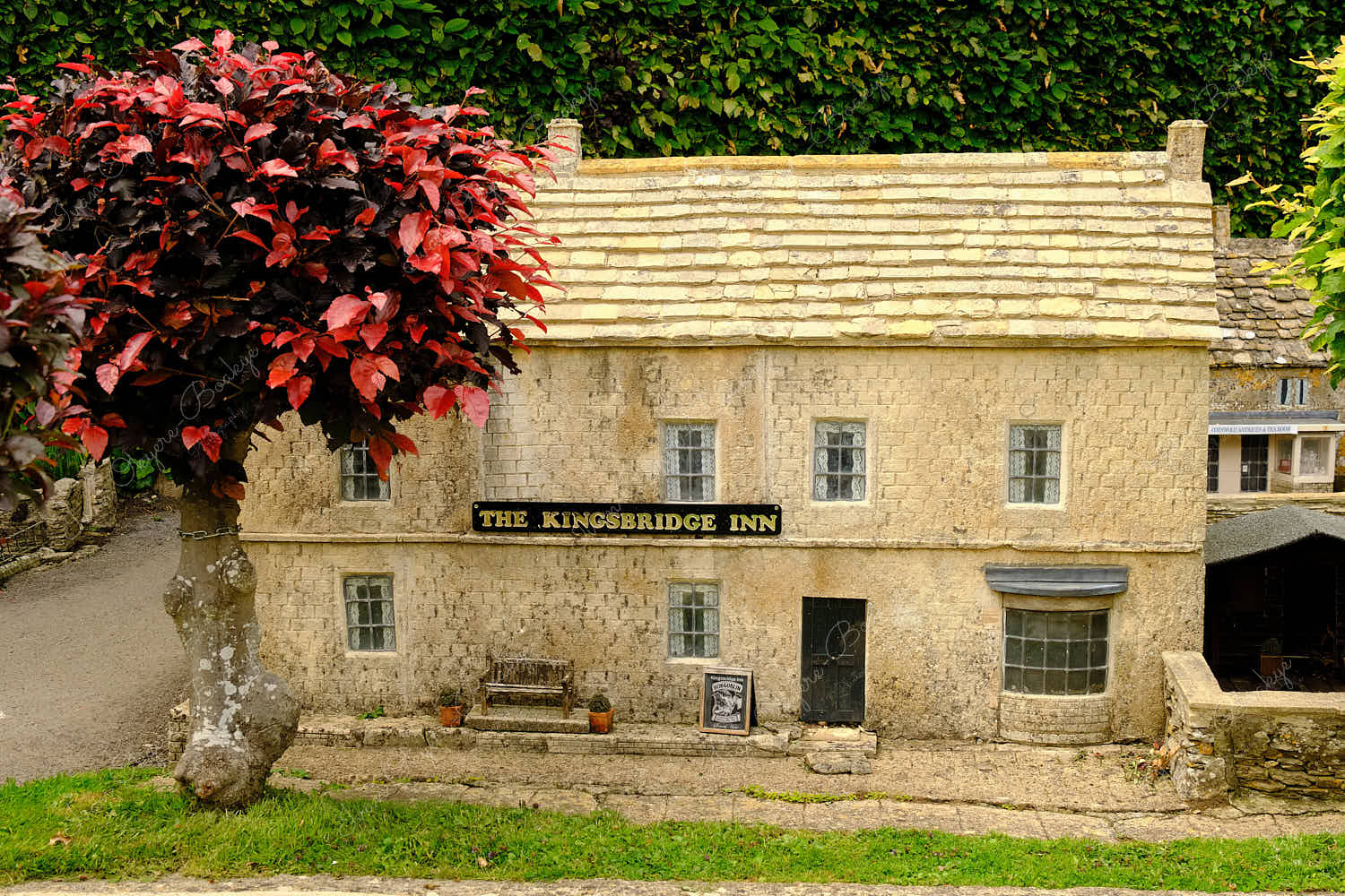 Elevated standing view of a miniature replica traditional English stone house Pub Inn in Bourton on the Water Model Village, England, UK