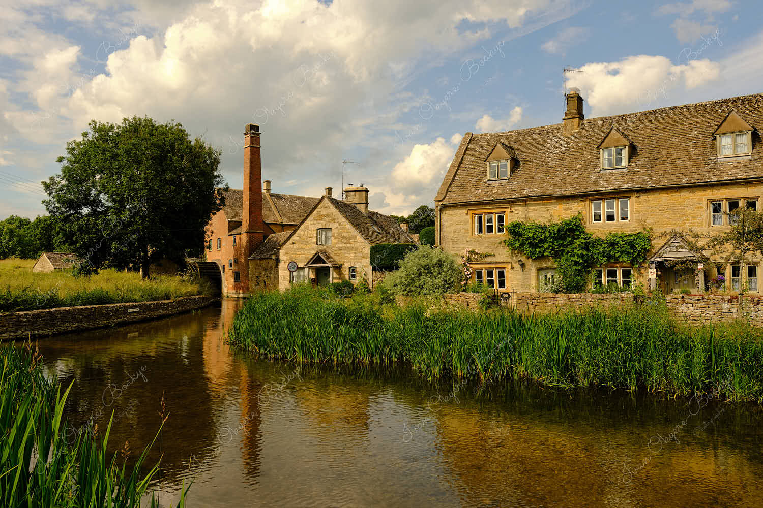 The Lower Slaughter Museum and water wheel along the picturesque River Eye in Bourton on the Water, Cotswolds, Gloucestershire, England, UK