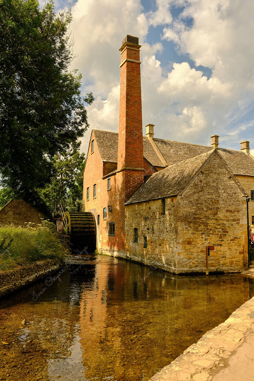The Lower Slaughter Museum and water wheel along the picturesque River Eye in Bourton on the Water, Cotswolds, Gloucestershire, England, UK