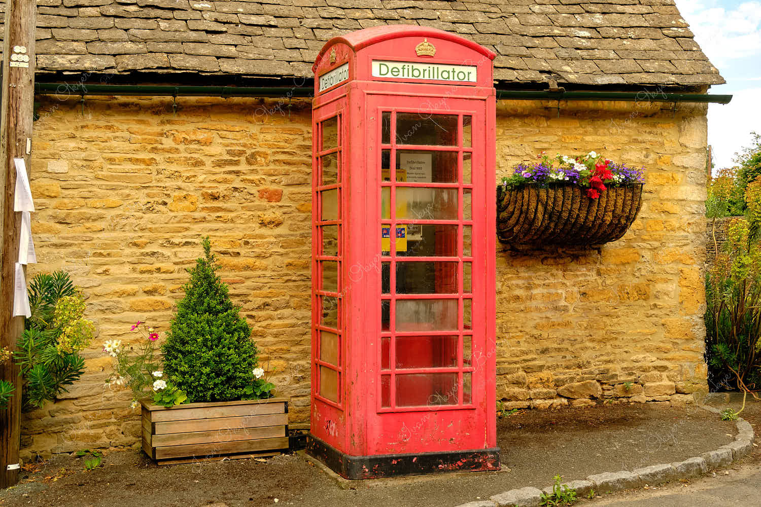 Defibrillator access point in a converted classic red British Phone Box, Cotswolds, Gloucestershire, England, UK