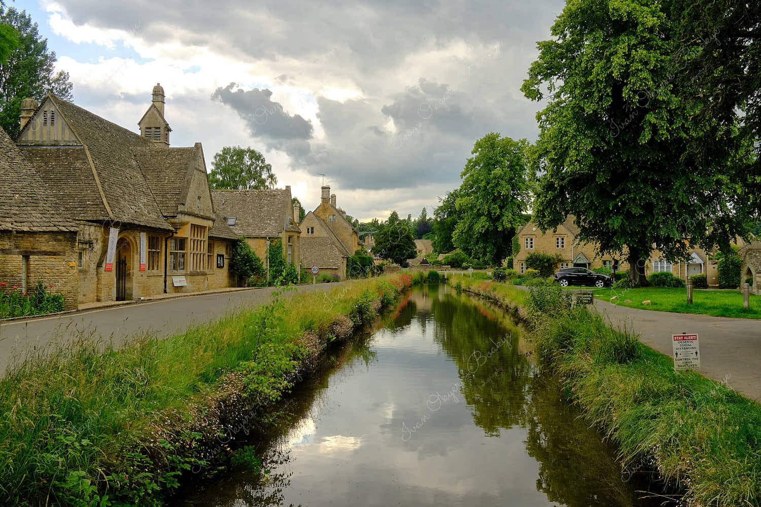 Traditional English stone cottages along the picturesque River Eye in Bourton on the Water, Cotswolds, Gloucestershire, England, UK