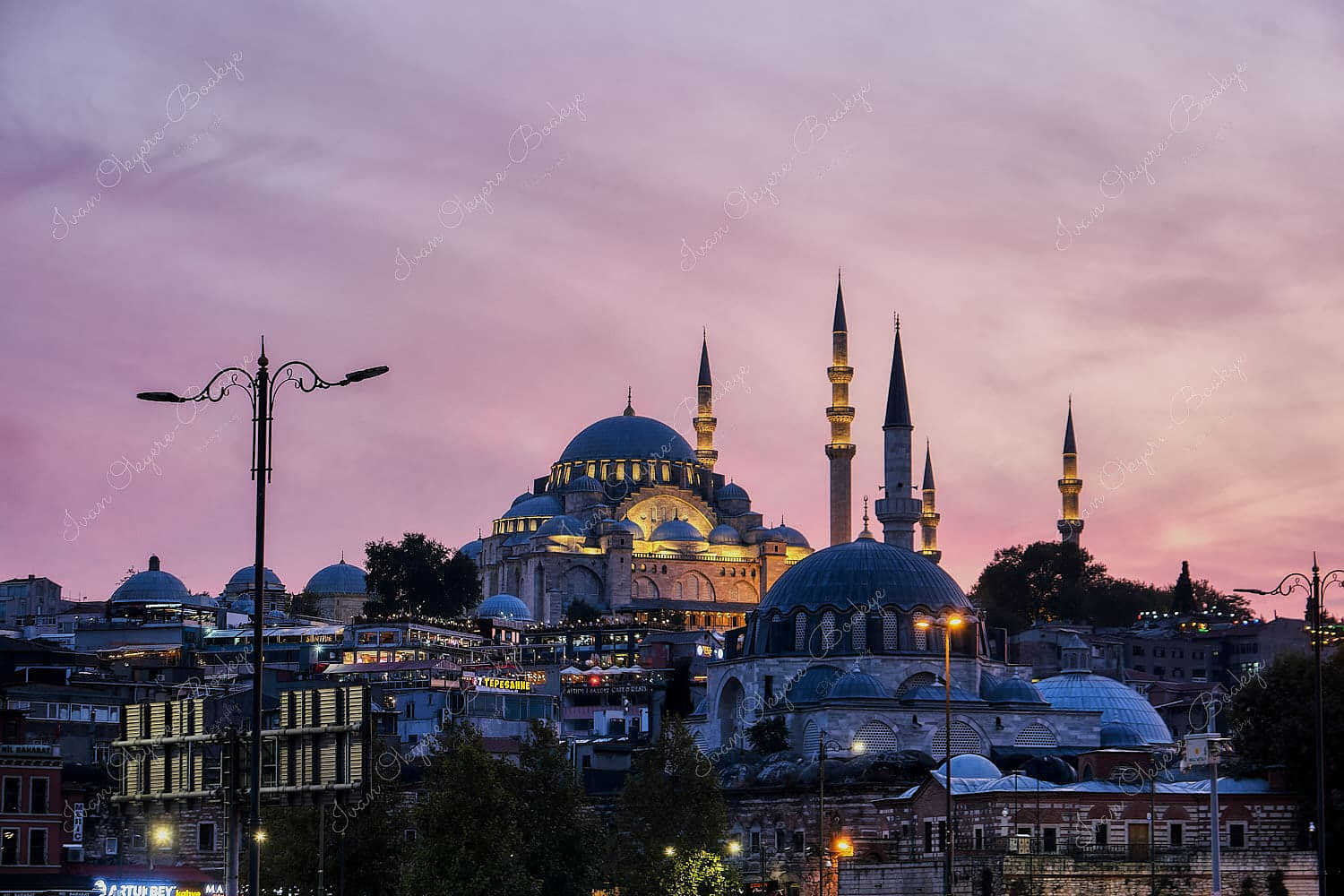 View of illuminated Suleymaniye Mosque at sunset from Eminonu harbour, Istanbul, Turkey