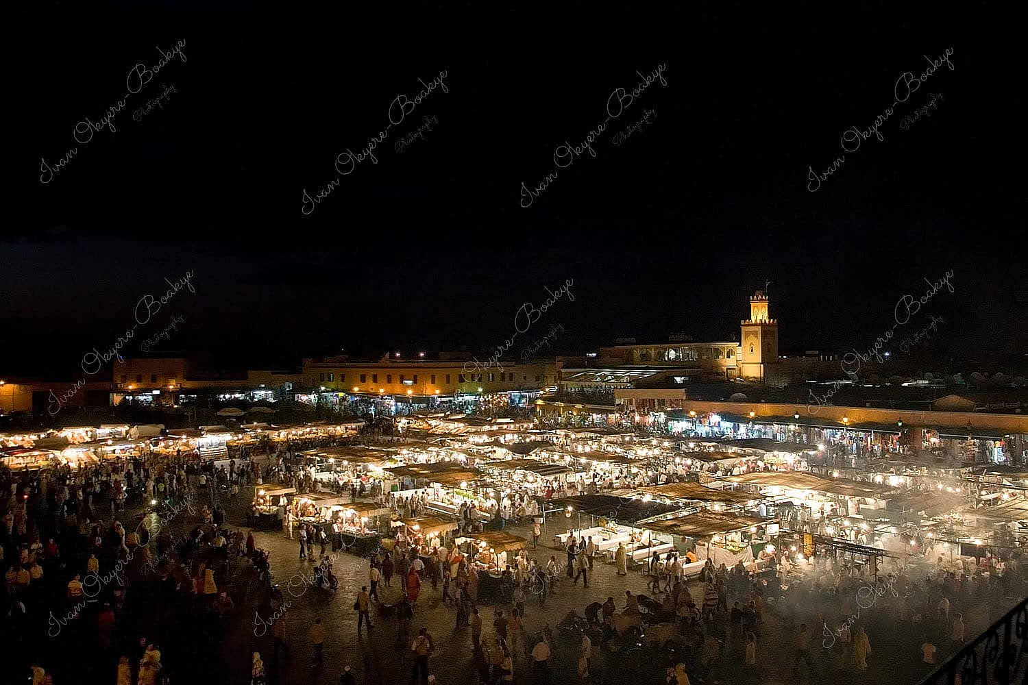 Panoramic night view of the famous Djemaa el-Fna night market with smoke rising from the various food stalls, Marrakesh, Morocco