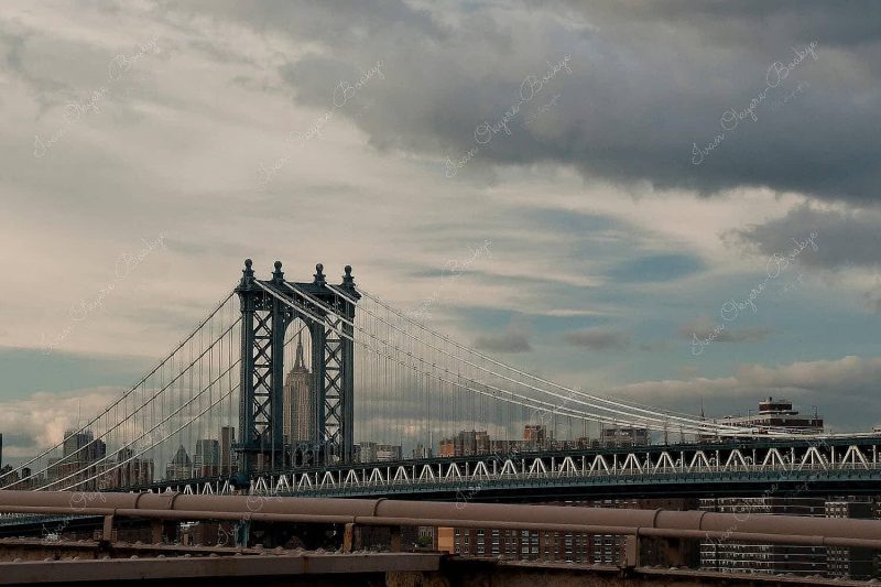 View of Empire State Building through Manhattan bridge, New York, America