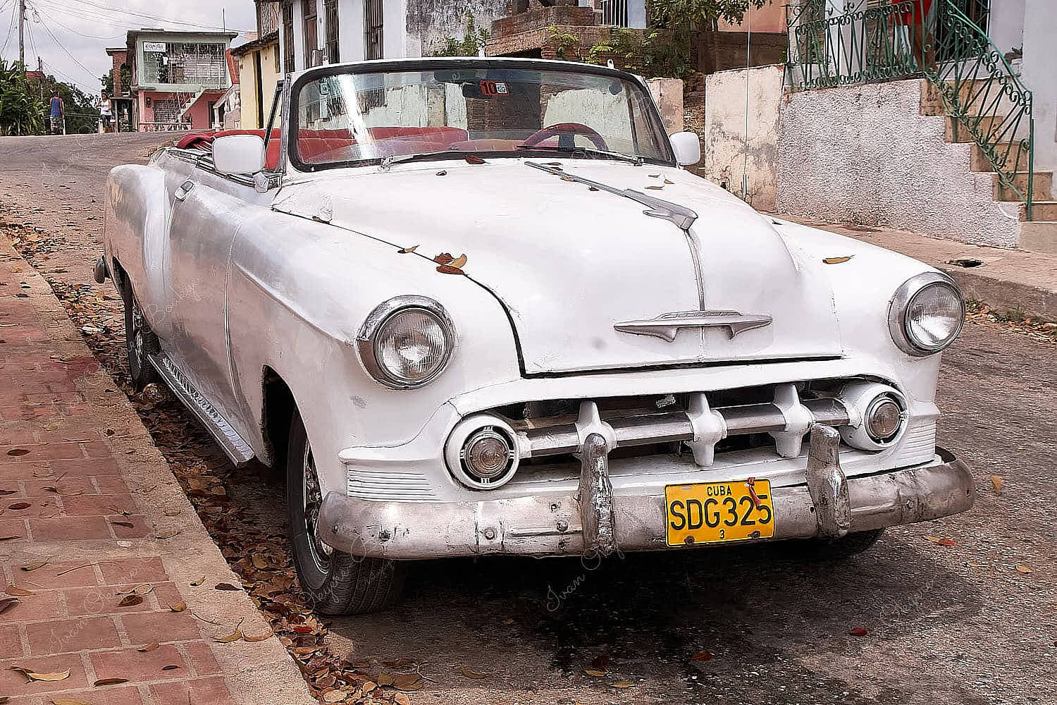 An old but clean and well maintained white classic Chevrolet American car parked in the streets of Trinidad, Cuba
