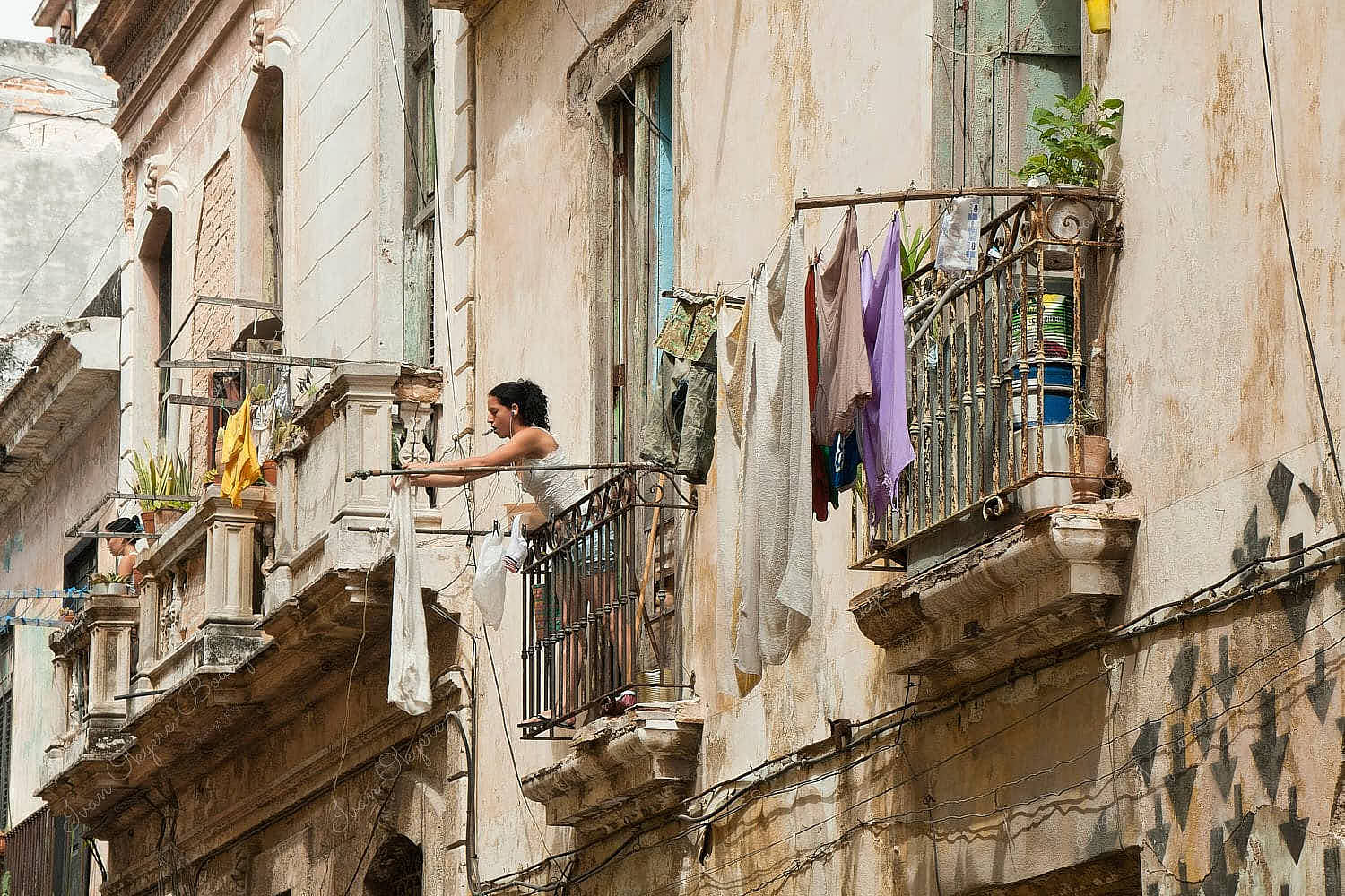 Cuban woman hanging washed clothes in the side streets of Habana Vieja, Havana, Cuba