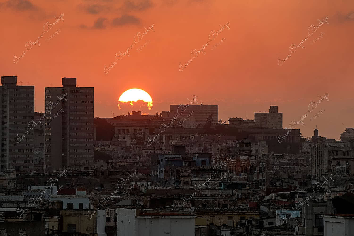 A beautiful low sun setting over the rooftops of old apartment buildings in Centro Habana, Cuba