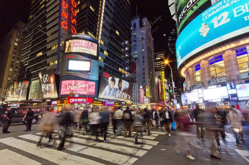 Busy pedestrian crossing at night in Times Square, New York, America