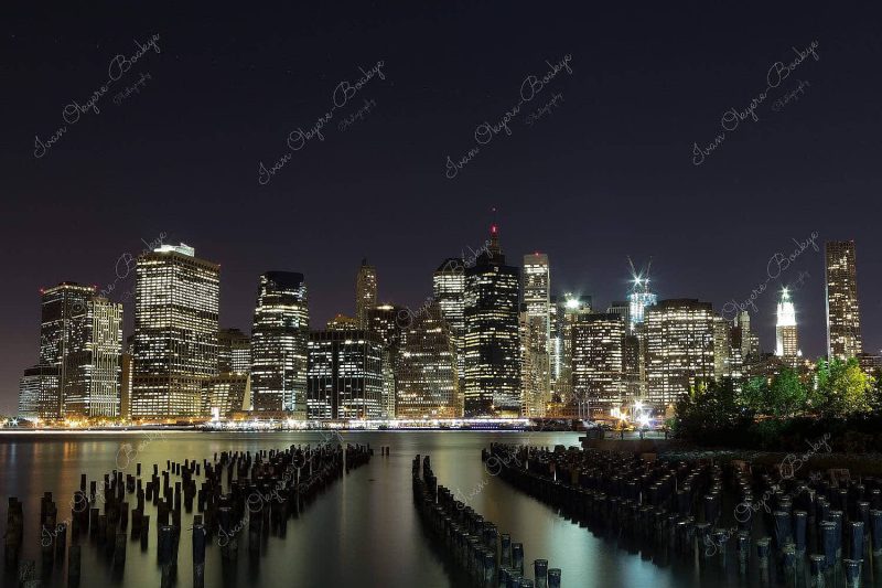 Long exposure landscape view of Manhattan skyline with groynes in the foreground, New York, America