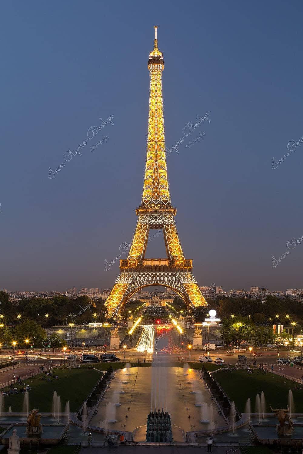 Fountains leading up to an illuminated Eiffel Tower at night in Paris, France
