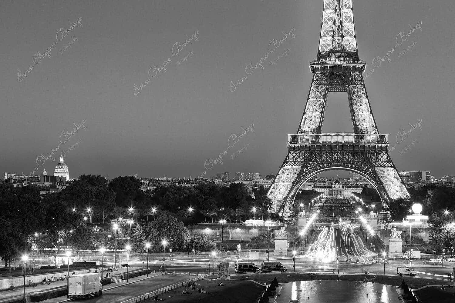 Traffic light trails leading up to an illuminated Eiffel Tower at night in Paris, France