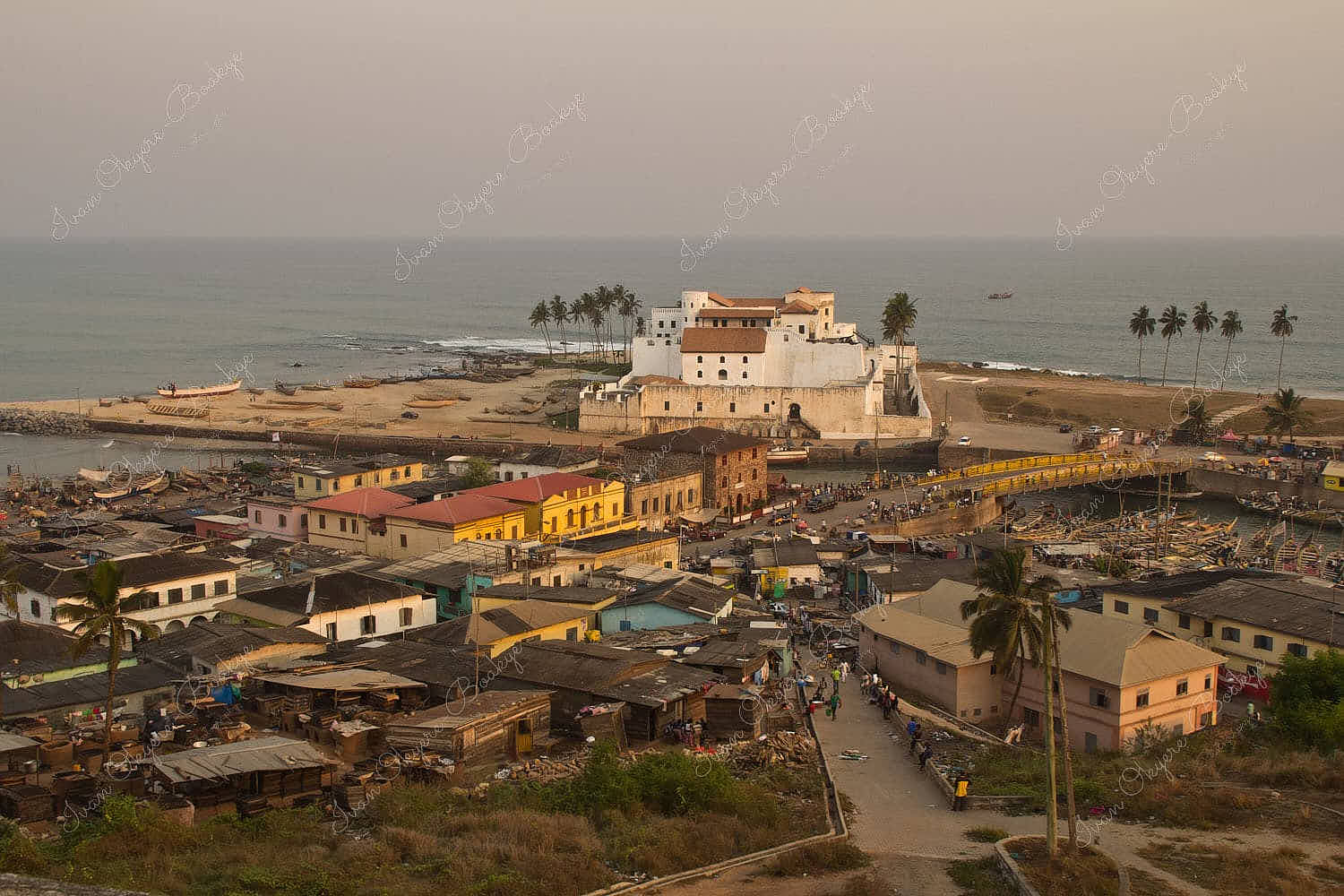 Elmina Castle and fishing village at sunset in Elmina, Cape Coast, Ghana