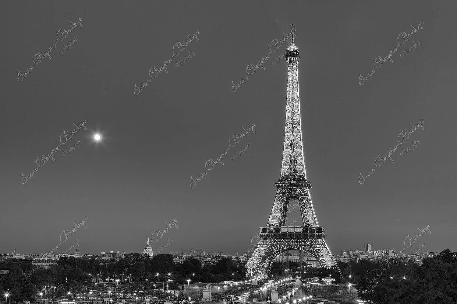 Traffic light trails leading up to an illuminated Eiffel Tower at night in Paris, France