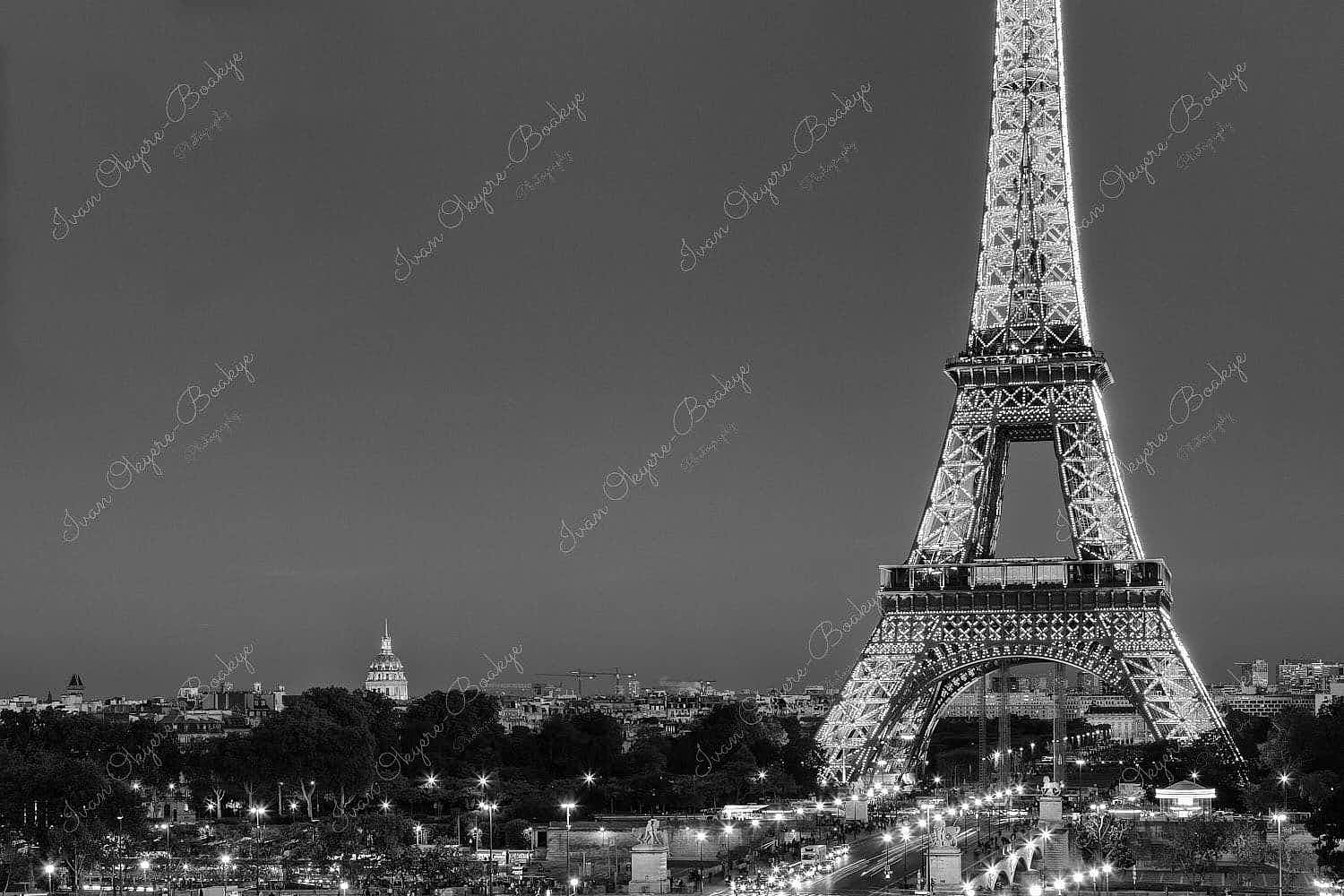 Traffic light trails leading up to an illuminated Eiffel Tower at night in Paris, France