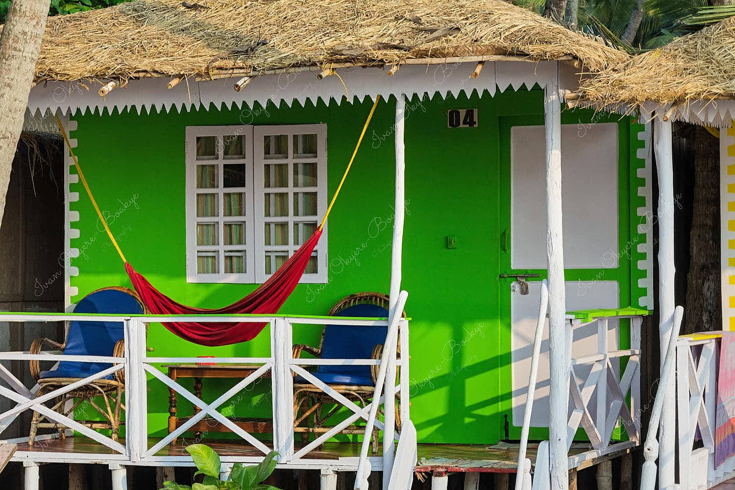 Beatiful green beach hut with a red hammock at Palolem Beach in Goa, India