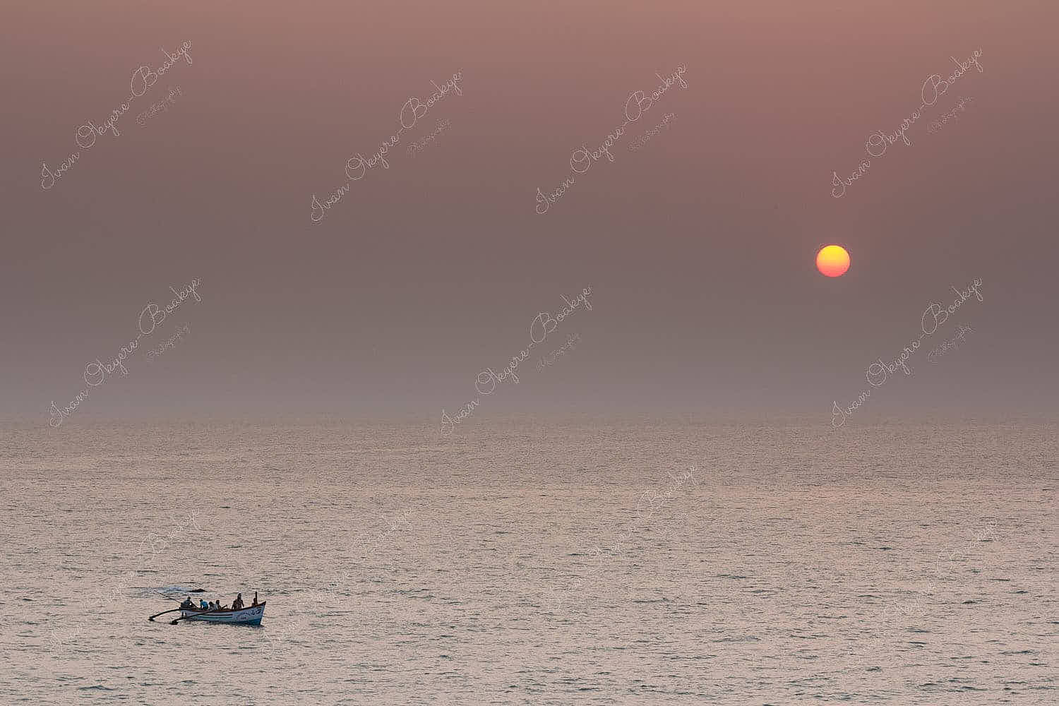 Fishermen fishing in the sea at sunset off Palolem Beach in Goa, India