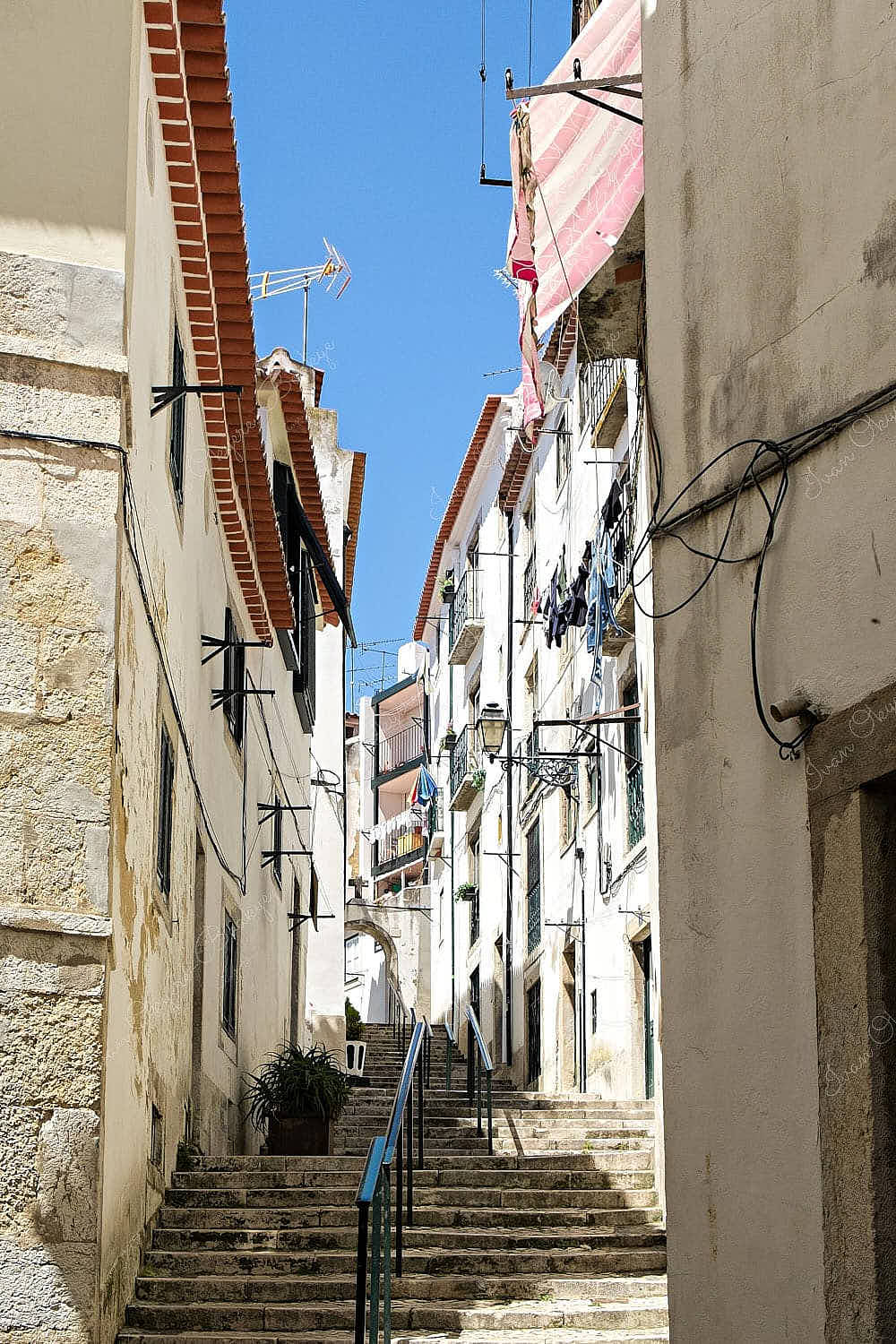 Narrow alleyway with hanging washing outside apartments in Alfama, Lisbon, Portugal