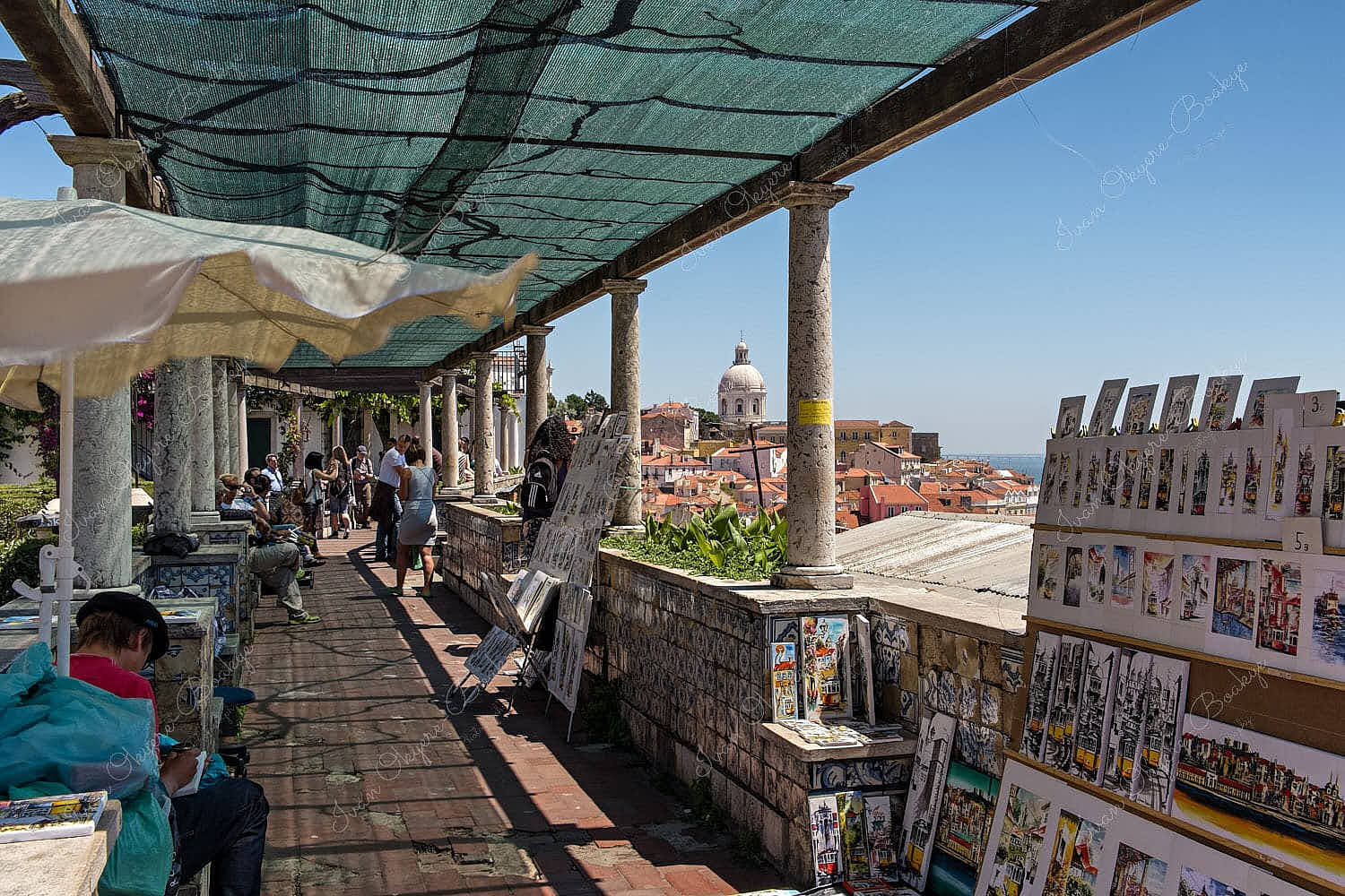 Tourists enjoying views of Alfama and Igreja de Santa Engrácia from Miradouro de Santa Luzia, in Alfama, Lisbon, Portugal