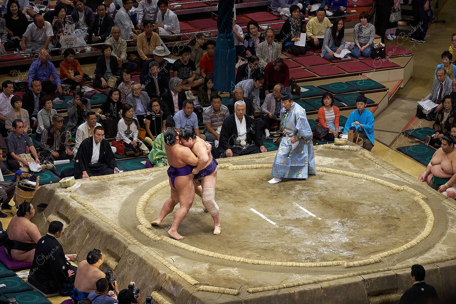 Sumo wrestlers fighting in the wrestling ring at 2013 September Grand Sumo Tournament at the Ryogoku Kokugikan, Tokyo, Japan