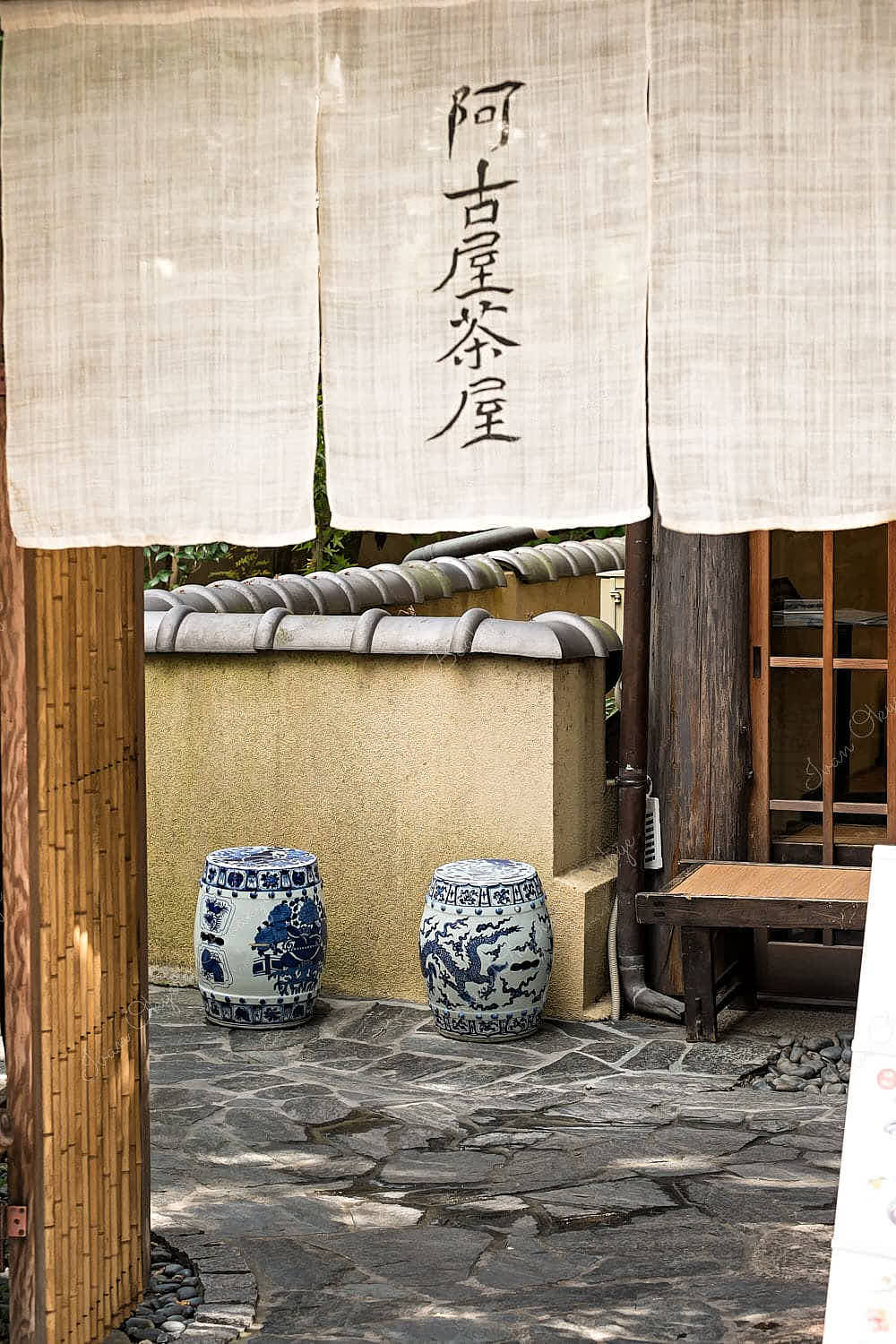 Doorway to a Japanese house with hanging cloth and japanese decorated floor vases in Kyoto, Japan