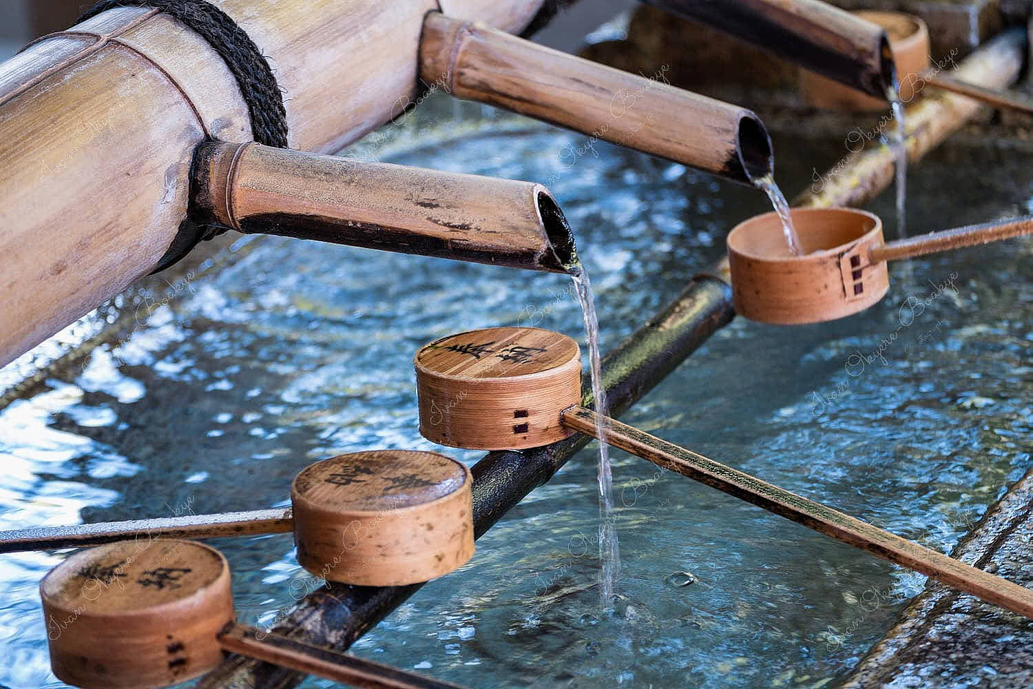 Water flowing from a Chōzubachi (water vessel) in water ladles at Yasaka Shrine, Kyoto, Japan