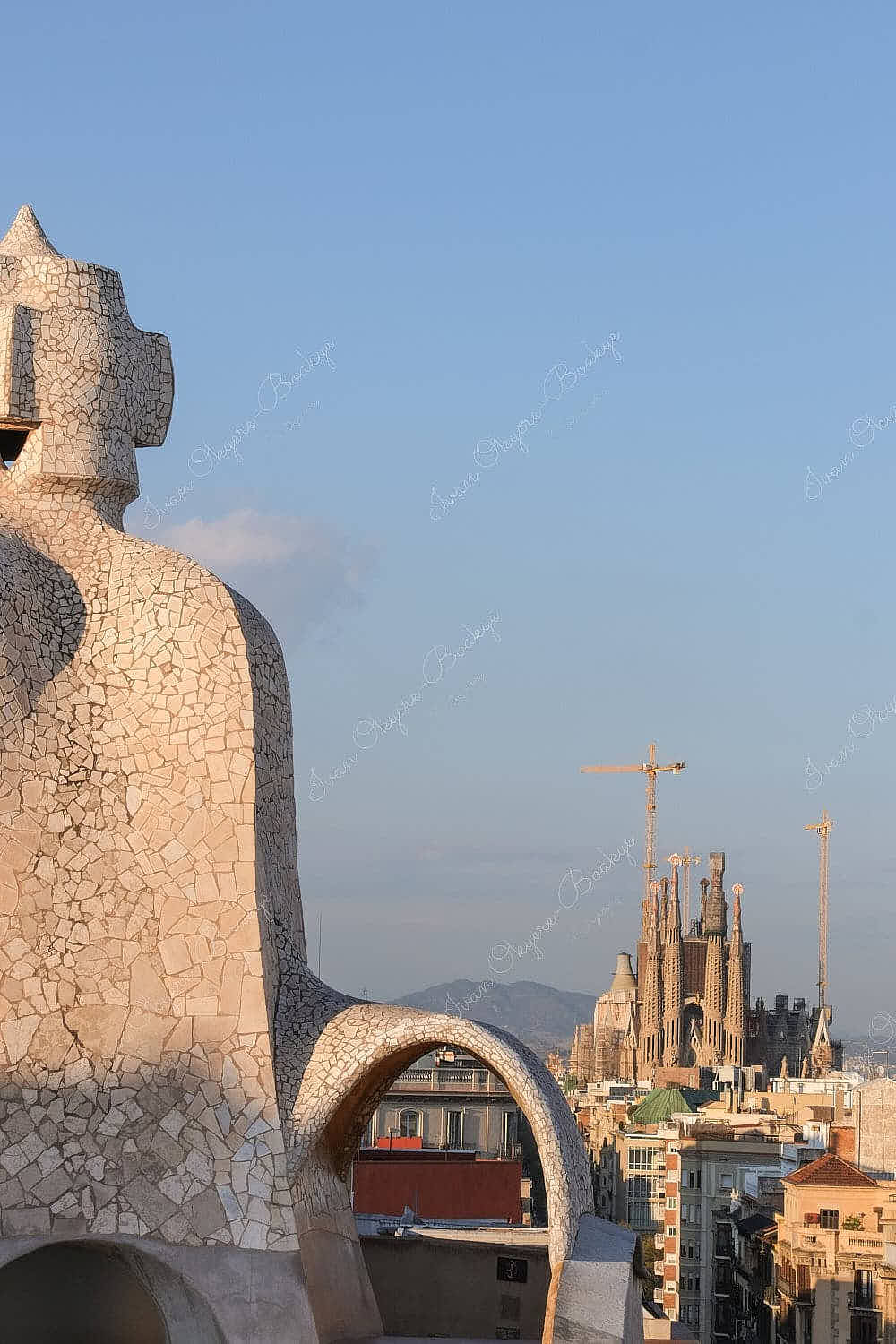 Antoni Gaudí styled chimney on rooftop of La Pedrera with view of Basílica de la Sagrada Família, Barcelona, Spain