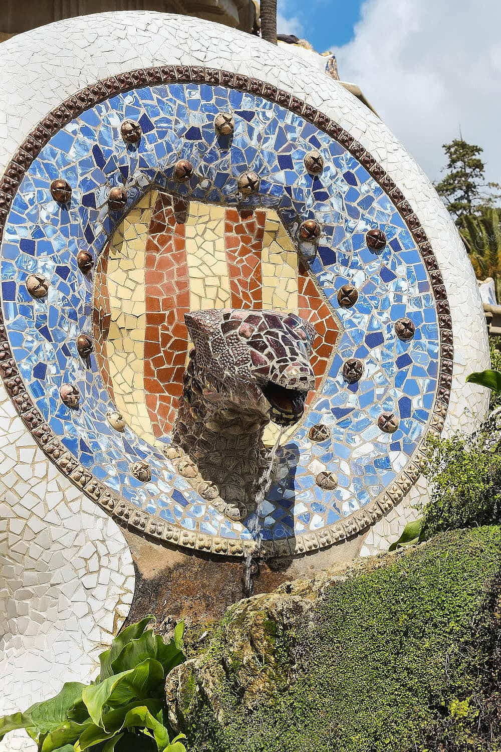 Tile shard mosaic design snake head fountain in Park Güell, Barcelona, Spain