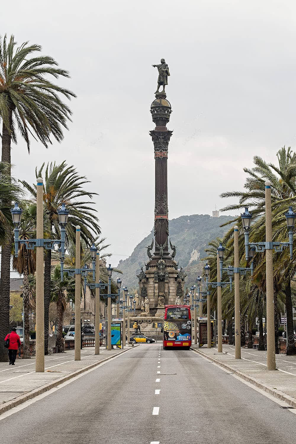 View of Columbus Monument from the palm tree lined Passeig de Colom street, Barcelona, Spain
