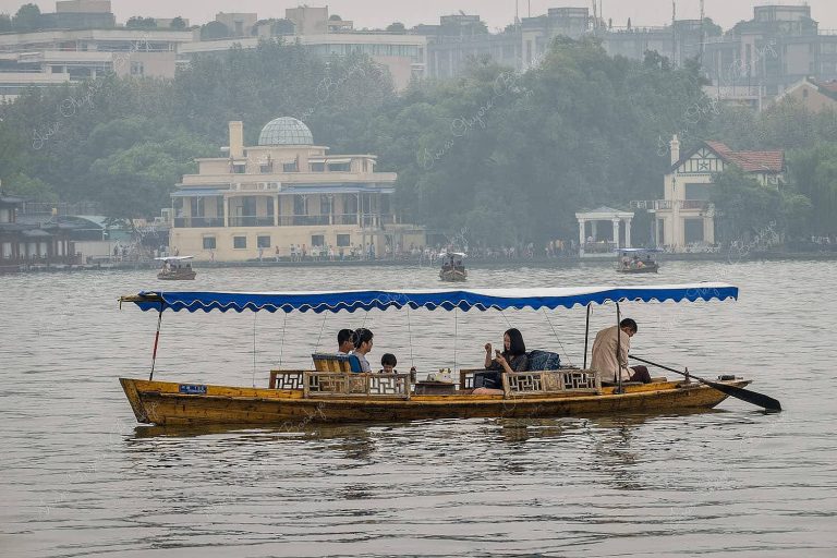 Family in row boat in West Lake, Hangzhou, China