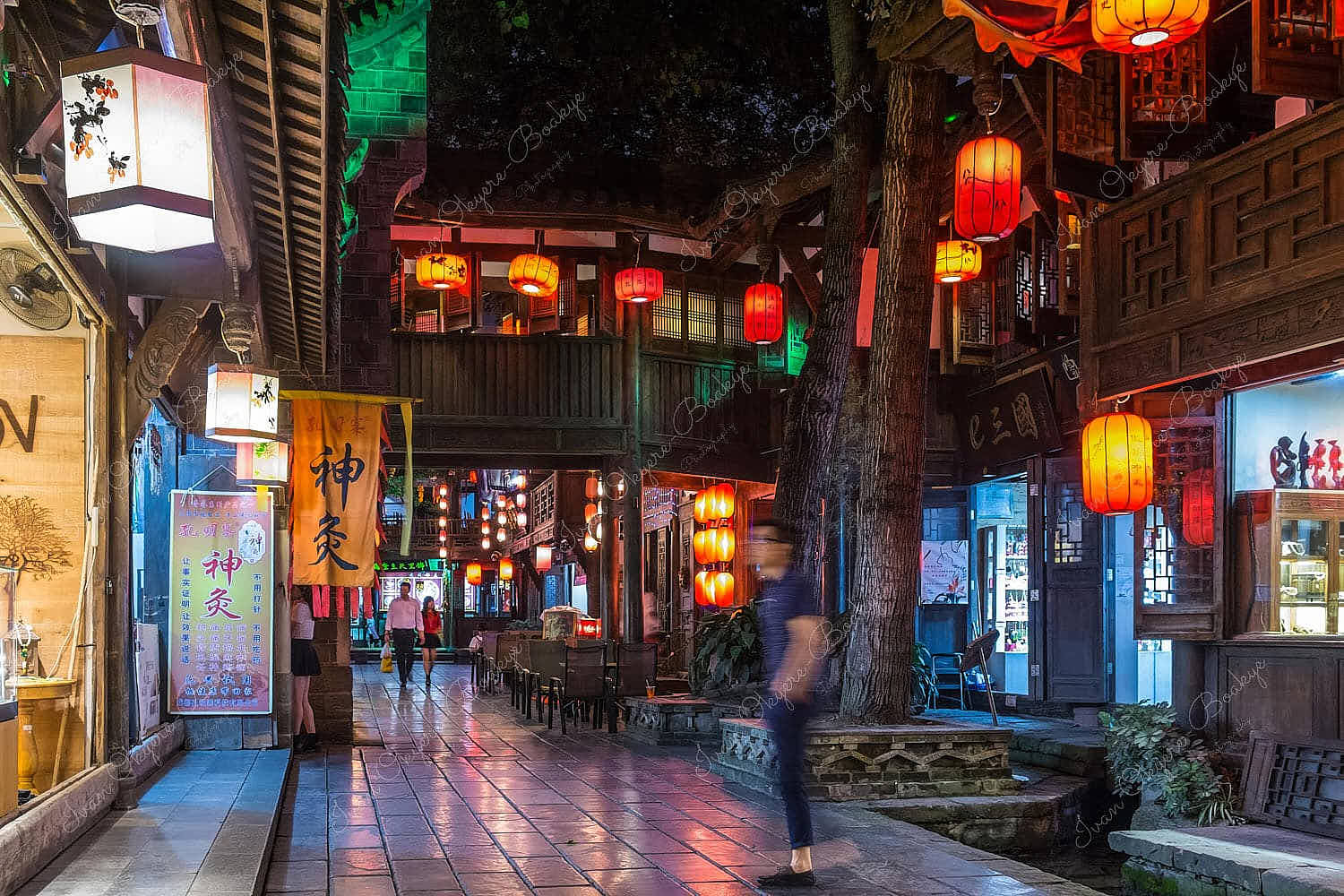 People walking by restaurants at night in Chengdu, China