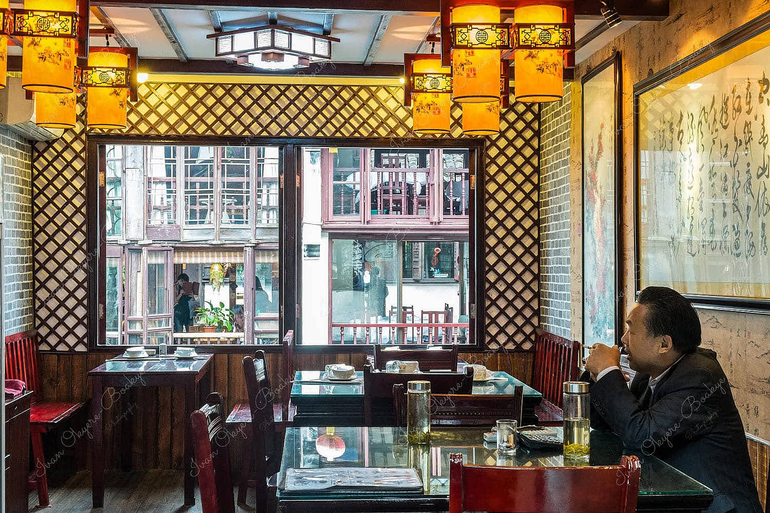 Chinese man eating alone in a traditional Chinese restaurant in the historic scenic Zhouzhuang water town, China