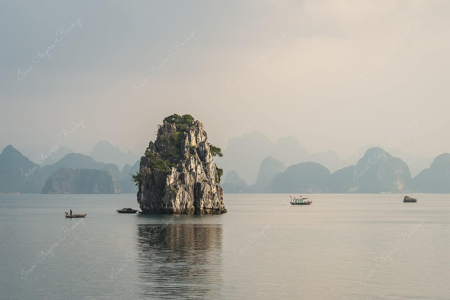 Fisherman in their fishing boats surrounded by karst mountains at dawn in Halong Bay, Vietnam
