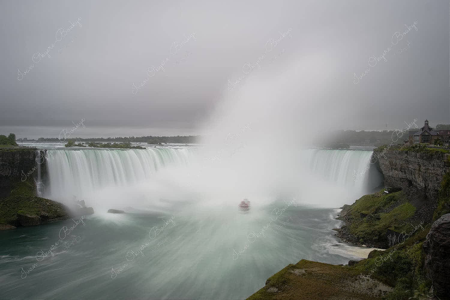 Panoramic view of Niagara Falls tour boat sailing into the Horseshoe Falls waterfall with water mist drifting upwards towards the sky, Ontario, Canada