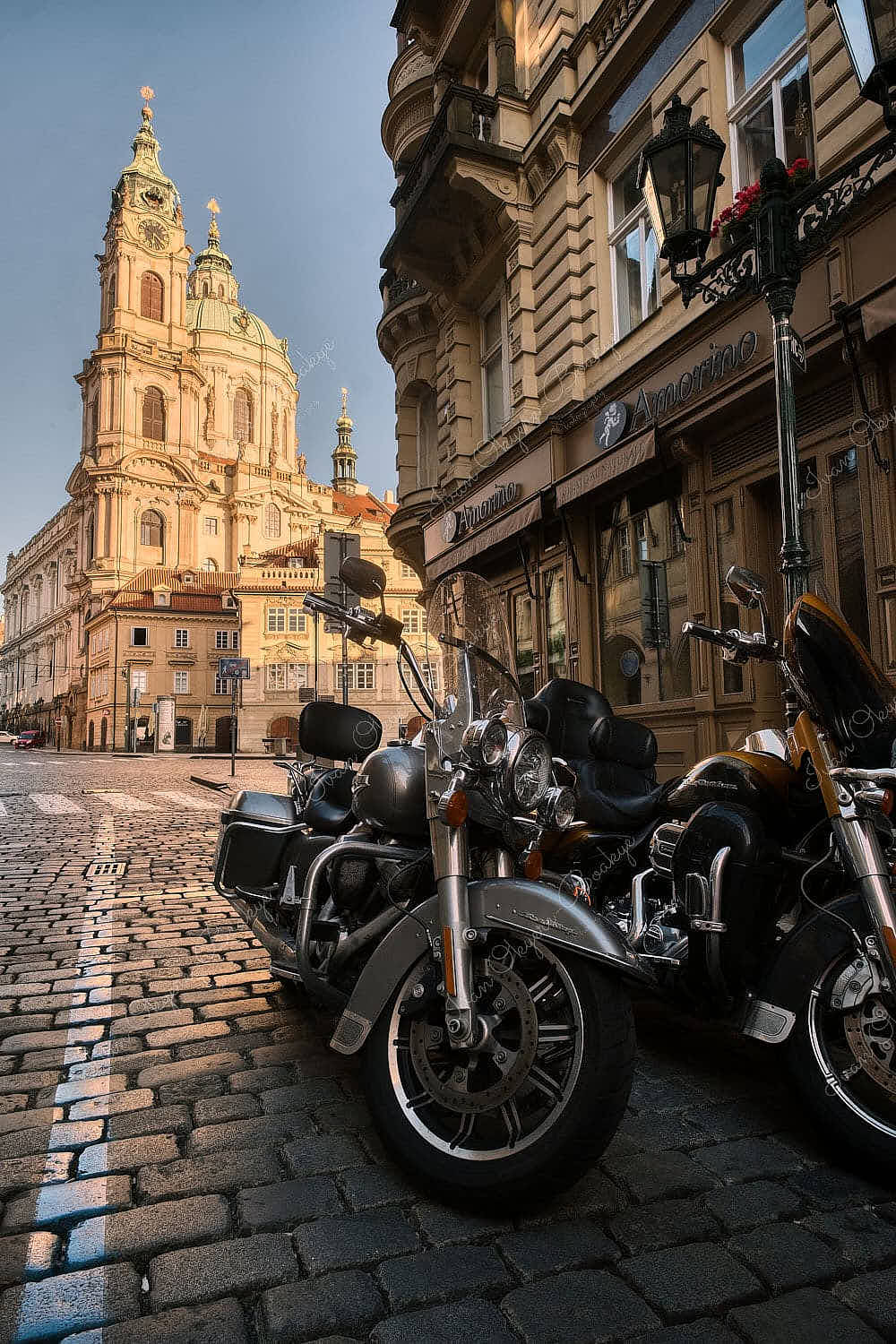 Harley Davidson motorbikes parked in side street in front of St Nicholas Church, Prague, Czech Republic