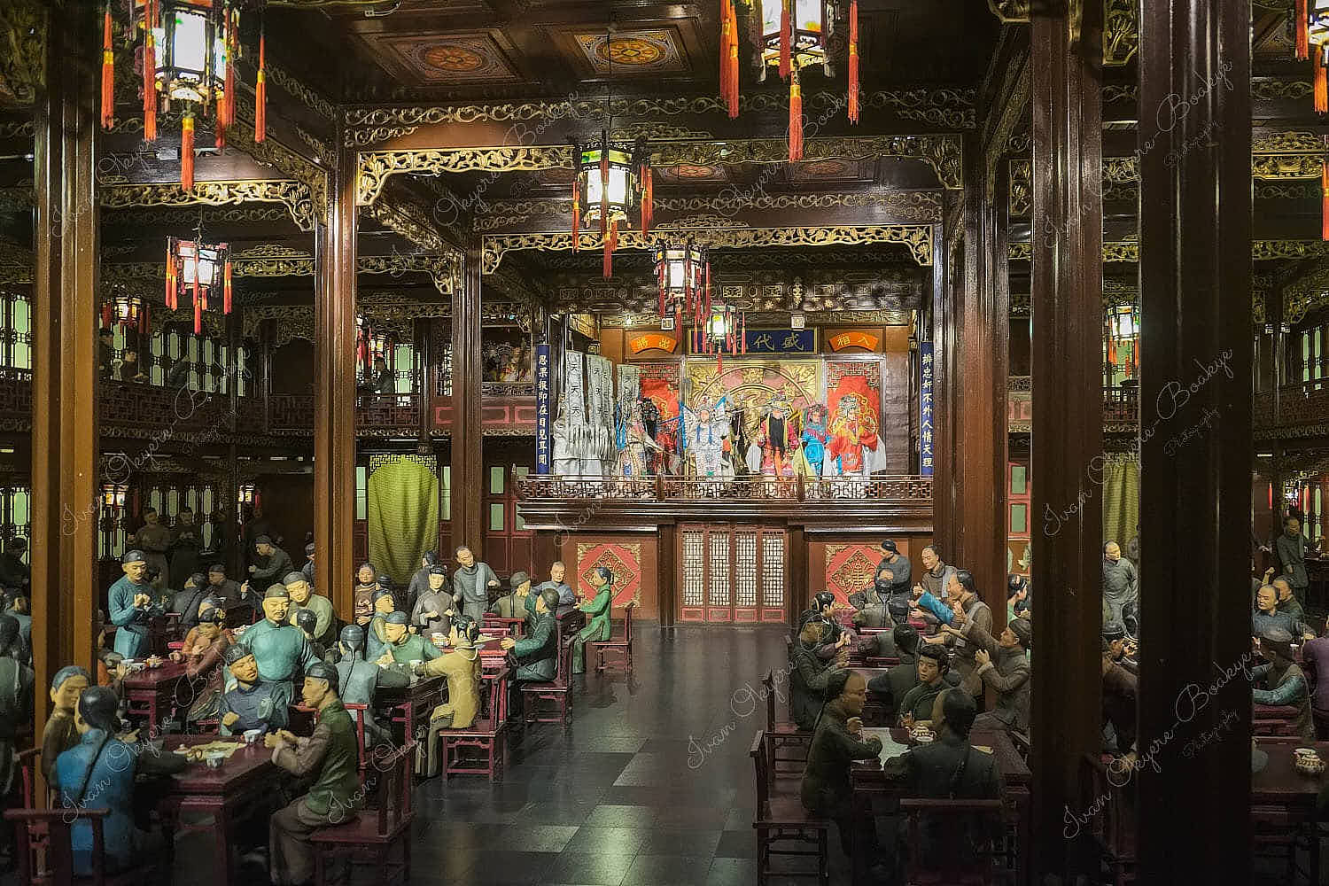 A replica of the inside of an ancient Chinese restaurant with figurines of people in traditional clothing dining and being entertained by actors on stage playing a Chinese warriors scene in Shanghai History Museum, China